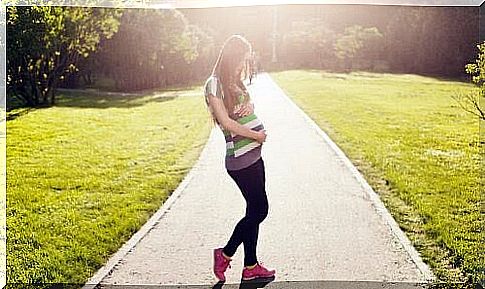 pregnant woman walking in backlight