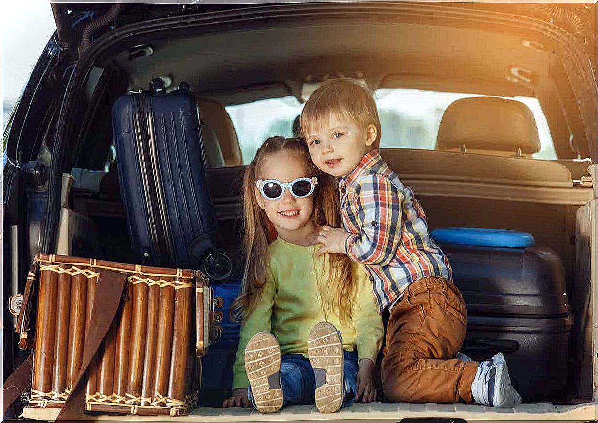 Two children sit in the back of an SUV and get ready to travel.