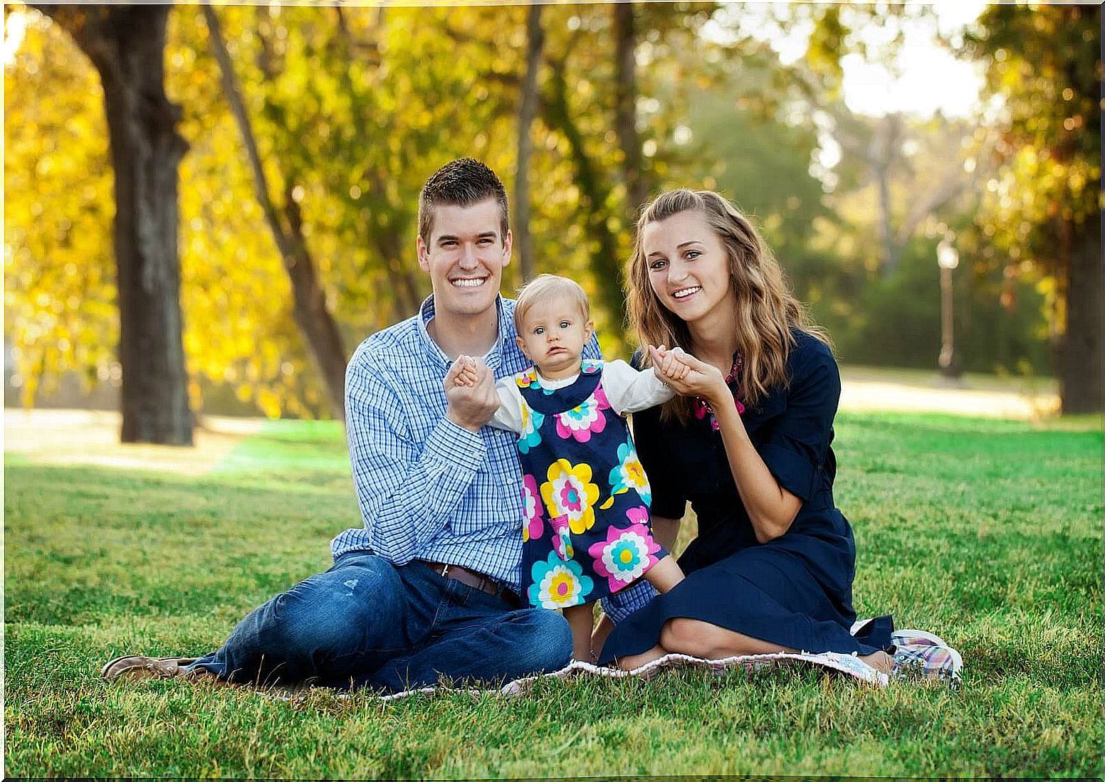 Mom, dad and baby in the grass