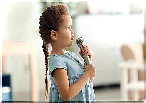 Children sing into a microphone.