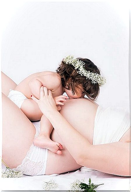 Girl kissing mom's belly