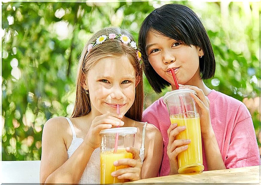 Two girls drink juice