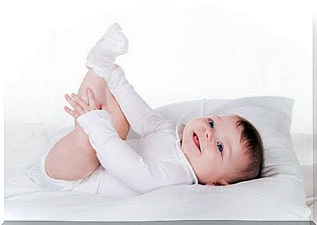 Baby on changing table playing with her feet