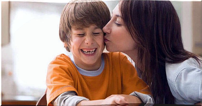 happy boy gets a kiss from his mom