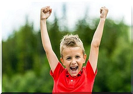 boy with good self-confidence makes victory gesture