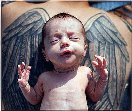 baby on top of tattooing wings