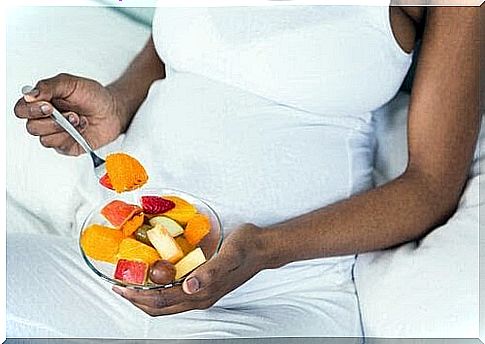 snack for the third trimester: pregnant woman with fruit bowl