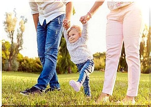 A child walks between his parents.