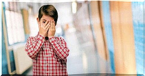 harmful shame: boy hides face in hands