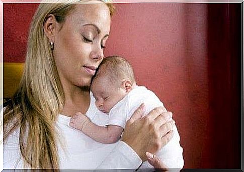 mom holding sleeping baby