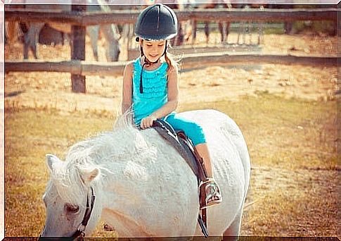 therapy animals help children: girl on horseback