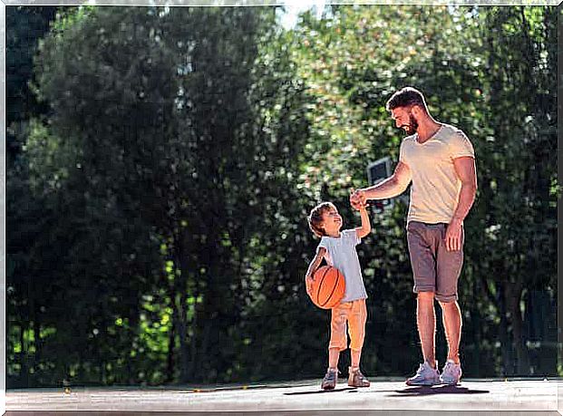 A father playing basketball with his son.