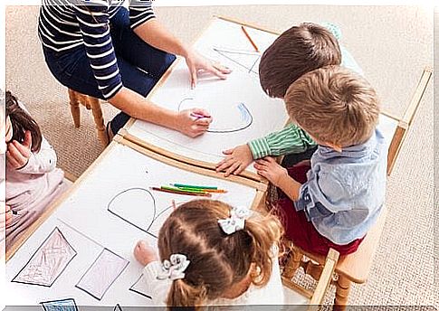 children in a school environment draw letters