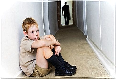 A child is sitting on the floor in the hall.