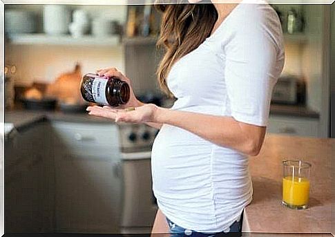 pregnant woman shakes pills out of a jar