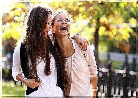 Two women hold each other and laugh