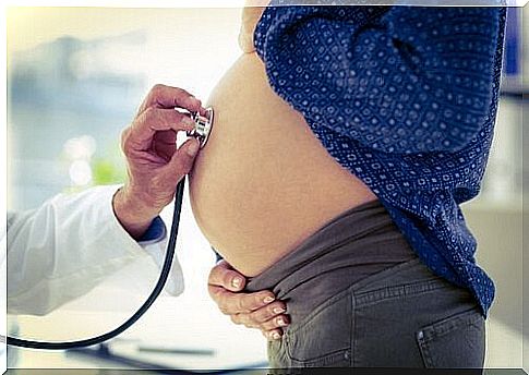 A pregnant woman is being examined by a doctor.