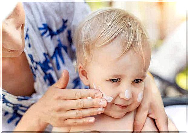 Mom applies sunscreen to her baby.