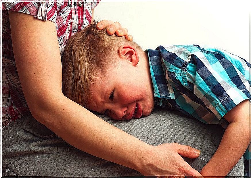 boy crying in his mother's lap