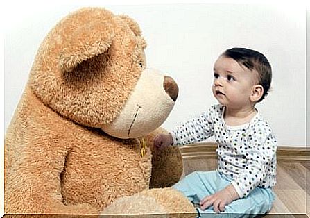 Sitting baby with teddy bear