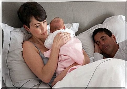 Mother holding baby in bed