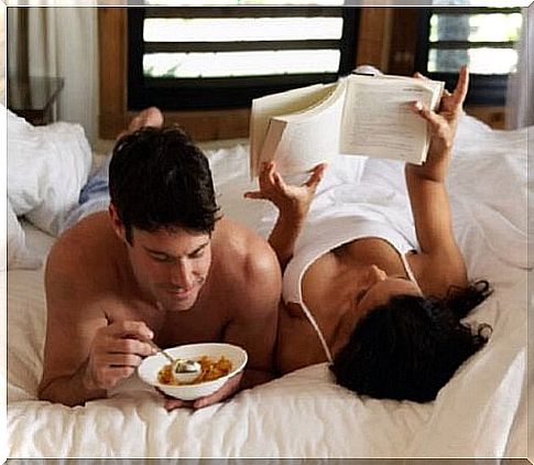 Couple in bed with breakfast