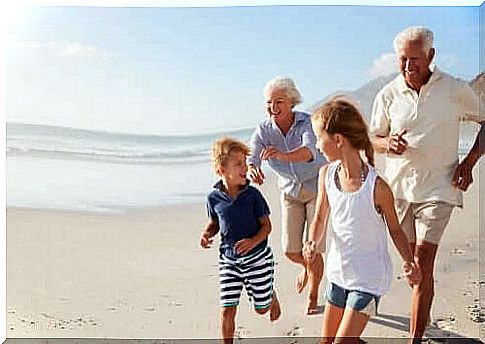 grandparents playing with grandchildren on beach