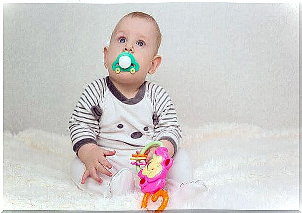 sitting baby with pacifier