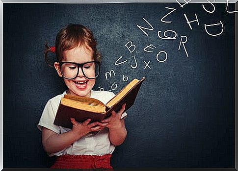 learn to read: children with book in front of blackboard