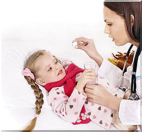 mother gives medicine to children in bed