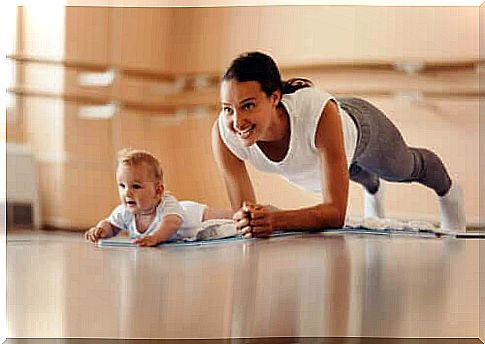 mother makes the plank and baby lies next to her on her stomach